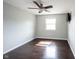 An airy bedroom features a ceiling fan, dark wood flooring, and a window that lets in natural light at 1477 Macintosh Ct, Avon, IN 46123