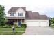 Charming two-story home featuring a two-car garage, well-manicured lawn, and a welcoming front porch at 1477 Macintosh Ct, Avon, IN 46123