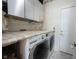 A laundry room with modern washer and dryer, storage cabinets, and a spacious countertop at 1477 Macintosh Ct, Avon, IN 46123