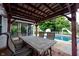 Covered patio area with seating, adjacent to a sparkling pool and lush green yard, perfect for outdoor living at 1477 Macintosh Ct, Avon, IN 46123
