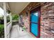 Inviting covered porch with a red brick wall, seating, and a vibrant blue door for a welcoming entrance at 1477 Macintosh Ct, Avon, IN 46123
