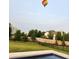 Well-manicured backyard featuring a beautiful in-ground pool and view of a hot air balloon in the sky at 15873 Hush Hickory Bnd, Westfield, IN 46074