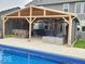 Outdoor kitchen and lounge area beside pool featuring a grill, bar seating, and comfortable seating at 15873 Hush Hickory Bnd, Westfield, IN 46074