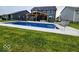 Relaxing backyard with a large pool, covered dining area, and lush green lawn, perfect for outdoor entertainment at 15873 Hush Hickory Bnd, Westfield, IN 46074