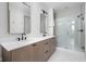 Bright bathroom with double vanity, framed mirrors, and glass-enclosed shower featuring neutral tile at 1677 Solebar Way, Westfield, IN 46074