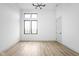 A clean bedroom with wood-look flooring, an electric outlet, and a modern light fixture at 1677 Solebar Way, Westfield, IN 46074