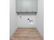 Empty laundry room with gray upper cabinets and wood laminate flooring at 1677 Solebar Way, Westfield, IN 46074