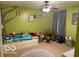 Bedroom with carpeted floors, green walls, ceiling fan, bed, and decorative tree art on the wall at 1711 Jaques Dr, Lebanon, IN 46052