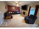 Comfortable living room with fireplace, plush seating, and large TV screen at 1711 Jaques Dr, Lebanon, IN 46052