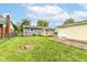 Backyard view of home, detached garage, wooden deck, fire pit and lush lawn at 1820 Hemlock Ln, Plainfield, IN 46168