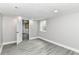 Basement with gray walls, wood floors, window, and a door leading into another room at 1820 Hemlock Ln, Plainfield, IN 46168