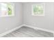 Bright, empty bedroom with two windows and grey vinyl flooring at 1820 Hemlock Ln, Plainfield, IN 46168