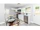 Bright eat-in kitchen featuring white cabinets, modern appliances, a glass dining table, and backyard views at 1820 Hemlock Ln, Plainfield, IN 46168