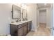 Bathroom features a double sink vanity, two large mirrors, neutral paint, wood-look flooring, and a walk-in closet at 2040 White Oak Dr, Shelbyville, IN 46176