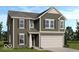 Charming two-story home with olive green siding, a two-car garage, and decorative shutters at 2040 White Oak Dr, Shelbyville, IN 46176
