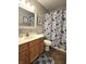 Traditional bathroom features a shower-tub combo with floral curtain, framed mirror, and wooden vanity at 2303 Eagle Brook Dr, Shelbyville, IN 46176