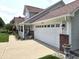 Attached two-car garage with additional parking, covered front porch and easy access to the house at 2303 Eagle Brook Dr, Shelbyville, IN 46176