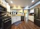 Updated kitchen features stainless steel appliances, white cabinetry, and wood flooring at 2303 Eagle Brook Dr, Shelbyville, IN 46176