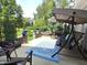 Cozy outdoor patio featuring a swing, seating, water feature, landscaping and plenty of shade at 2303 Eagle Brook Dr, Shelbyville, IN 46176