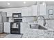 Modern kitchen features white cabinets, stainless steel appliances, and granite countertops at 248 Legends Creek Pl # 207, Indianapolis, IN 46229