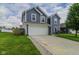 Two-story home with blue siding, a white garage door, driveway, and green lawn with a small tree at 2485 Bristol Dr, Franklin, IN 46131