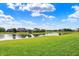 Scenic view of a lush green lawn extending to a serene pond with mature trees at 2789 W High Grove Cir, Zionsville, IN 46077