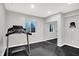 Basement gym area features a treadmill with dark rubber flooring and a mirror in the workout room at 2789 W High Grove Cir, Zionsville, IN 46077