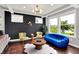 Stylish living room featuring a modern light fixture, unique blue couch, and large windows with neighborhood views at 2789 W High Grove Cir, Zionsville, IN 46077
