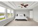 This main bedroom offers ample natural light with neutral walls and a ceiling fan for comfort and a view of a pond at 2789 W High Grove Cir, Zionsville, IN 46077