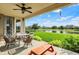 Inviting covered patio with stone fireplace, ceiling fan, and comfortable seating overlooking the yard and pond at 2789 W High Grove Cir, Zionsville, IN 46077