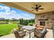 Outdoor patio with a stone fireplace, comfortable seating, and view of a pond at 2789 W High Grove Cir, Zionsville, IN 46077