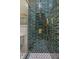 Close up on shower featuring gold fixtures, dark tiling, and glass door at 2831 N Talbott St, Indianapolis, IN 46205