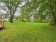 Expansive backyard, featuring mature trees and a large grassy lawn, offering space and shade at 308 Mohawk St, Anderson, IN 46012