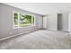 Spacious living room featuring neutral gray walls, plush carpeting, and plenty of natural light at 308 Mohawk St, Anderson, IN 46012