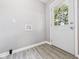 Neutral mud room with gray walls, laminate flooring, and a white exterior door with decorative glass at 308 Mohawk St, Anderson, IN 46012