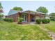 Charming backyard with a brick house, covered patio, and lush landscaping, a perfect retreat at 3303 Wedgewood Dr, Indianapolis, IN 46227