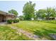 Large backyard featuring a brick house, patio, shed, and mature trees offers ample outdoor space at 3303 Wedgewood Dr, Indianapolis, IN 46227