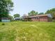 Generous backyard showcasing a brick home, covered patio, and a storage shed for outdoor essentials at 3303 Wedgewood Dr, Indianapolis, IN 46227