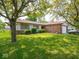 A charming single-story home featuring a lush green lawn, mature shade trees, and brick accents at 3303 Wedgewood Dr, Indianapolis, IN 46227