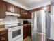 Well-lit kitchen featuring stainless steel refrigerator, white oven, and plenty of cabinet space at 3303 Wedgewood Dr, Indianapolis, IN 46227