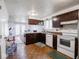 Kitchen area with dark cabinets and white appliances, next to the dining room at 3303 Wedgewood Dr, Indianapolis, IN 46227