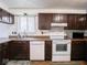 Kitchen with dark wood cabinets and white appliances at 3303 Wedgewood Dr, Indianapolis, IN 46227