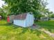 Charming light blue shed with brown roof, ideal for extra storage in a spacious, green backyard at 3303 Wedgewood Dr, Indianapolis, IN 46227