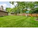 Large backyard with green grass, wooden fence, storage shed, and playset, creating an inviting outdoor space at 3304 Fox Orchard Cir, Indianapolis, IN 46214