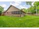 Well-kept backyard with green grass, brick house, shed, and flower bed, creating a peaceful outdoor setting at 3304 Fox Orchard Cir, Indianapolis, IN 46214