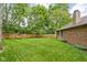 Lush backyard features a wooden fence, fire pit, and brick exterior, offering a serene outdoor retreat at 3304 Fox Orchard Cir, Indianapolis, IN 46214