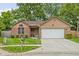 Charming single-story home featuring a manicured lawn, brick accents, and an attached two-car garage at 3304 Fox Orchard Cir, Indianapolis, IN 46214