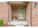 Charming entryway with a well-lit porch, potted flowers, and a welcoming 'hello' doormat at 3304 Fox Orchard Cir, Indianapolis, IN 46214