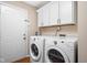 Laundry room with a washer and dryer, as well as storage cabinets above the machines at 3304 Fox Orchard Cir, Indianapolis, IN 46214