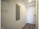 Hallway featuring a door and a breaker panel on a white wall, and modern gray laminate flooring at 350 N Meridian St # 505, Indianapolis, IN 46204